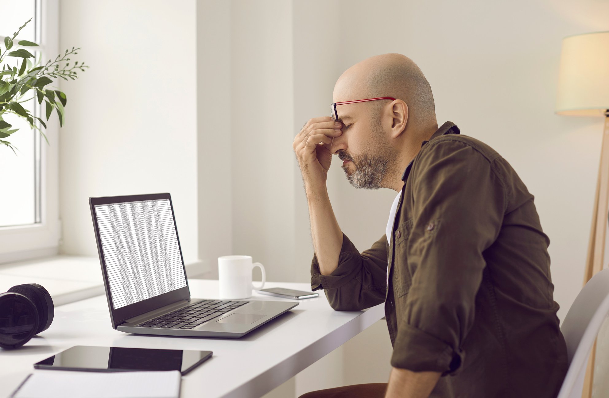 Stressed Tired Man Has Eye Strain Because of Constant Work on His Laptop Computer